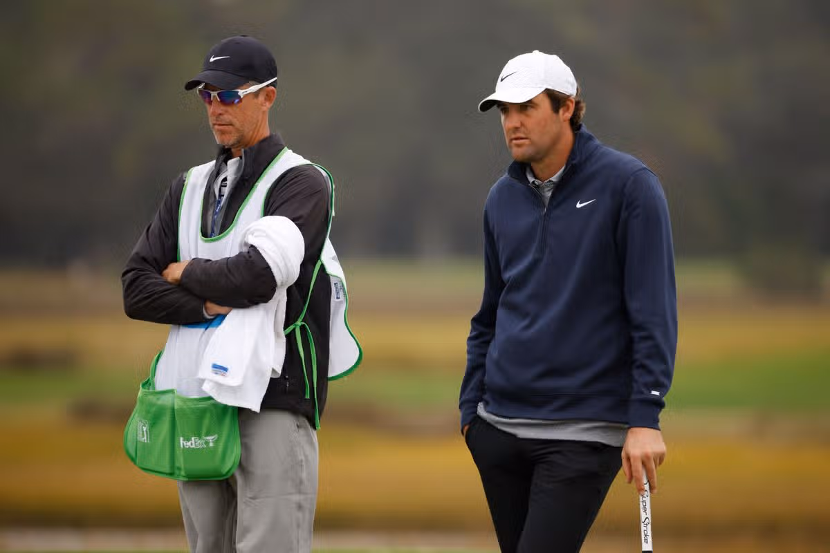 Scottie Scheffler of the United States and caddie Ted Scott look on over the fifth green during the third round of The RSM Classic on the Seaside Course at Sea Island Resort