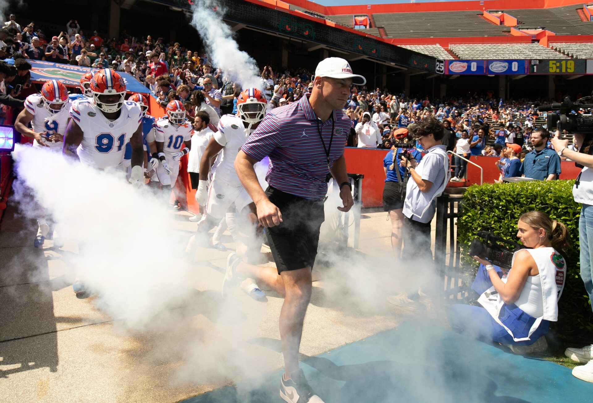 Florida head coach Jon Sumrall and the team blasts out onto the field before the Orange and Blue game at Steve Spurrier Field at