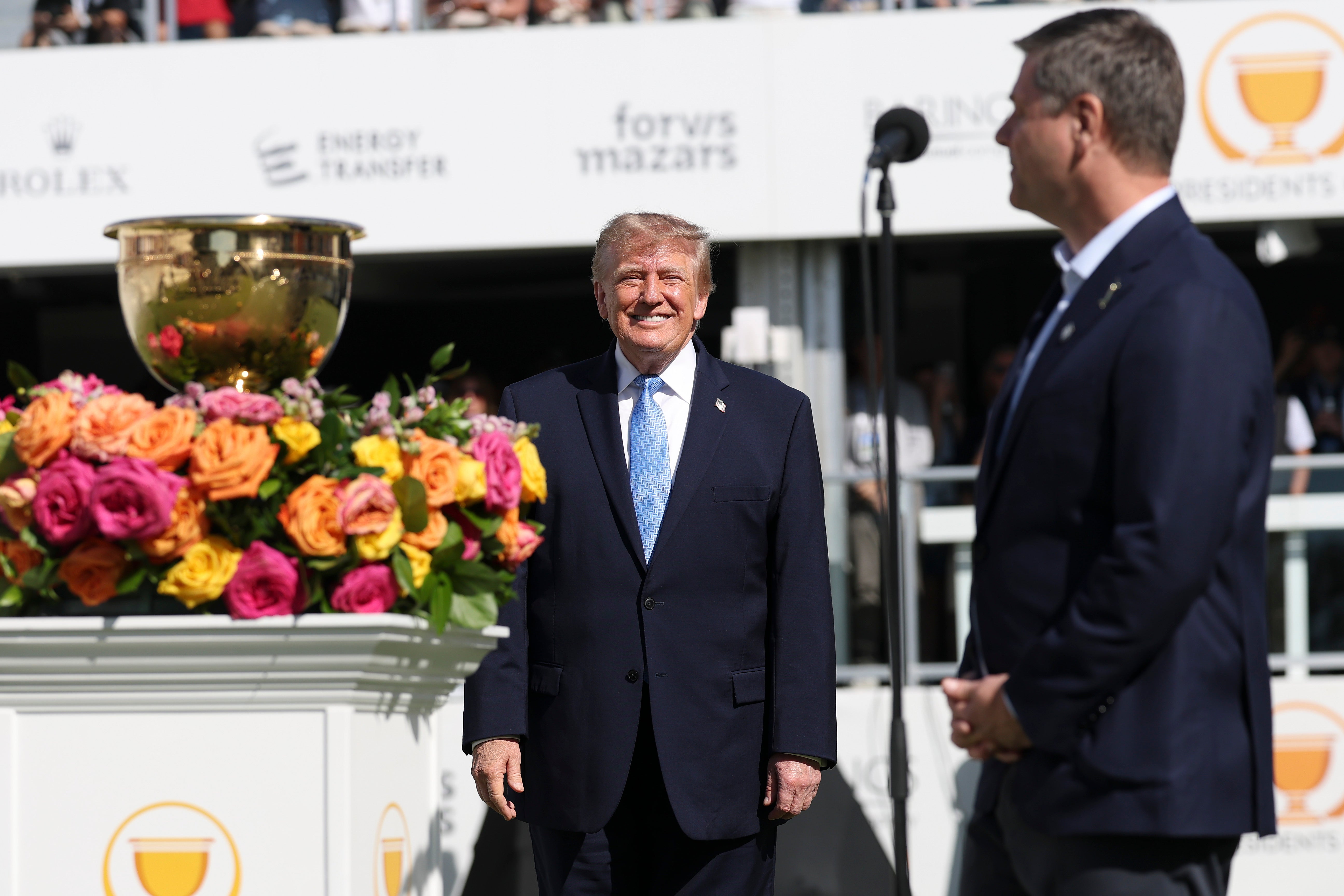 CEO of PGA Tour Brian Rolapp speaks as U.S. President Donald Trump stands on the first tee with the Presidents Cup trophy