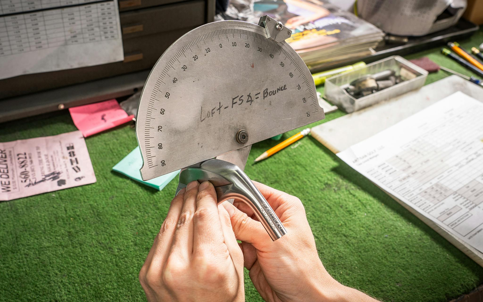 An employee measures the loft angle of an iron as part of a lengthy quality control process.