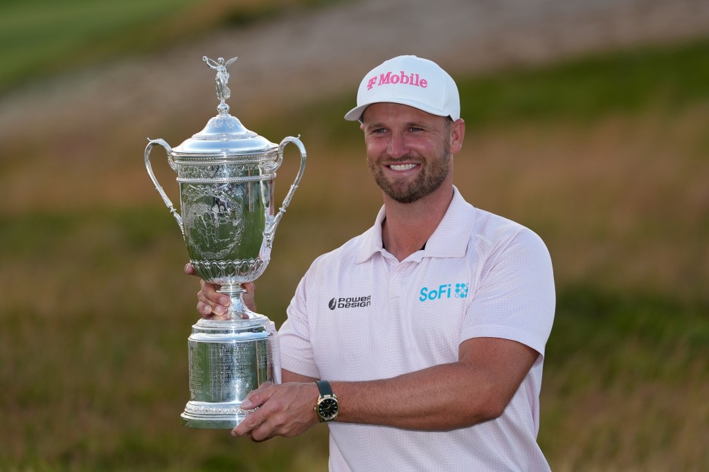 Wyndham Clark holds the trophy after winning the U.S. Open golf tournament at Shinnecock Hills Golf Club in Southampton, N.Y., Sunday, June 21, 2026.  