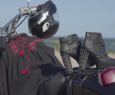 spiked shoes with high heels and black and red dress lying on the motorcycle close up th