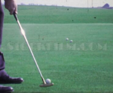 1968: Slow motion man putting golf balls practice green bullseye putter club. CEDAR RAPIDS, IOWA