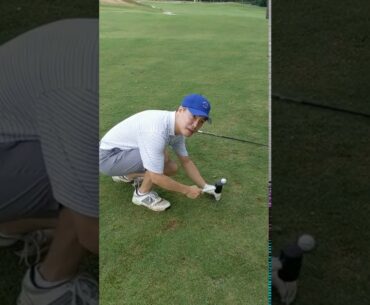 Hammering a tee into the tee box at Bobby Jones Golf Course