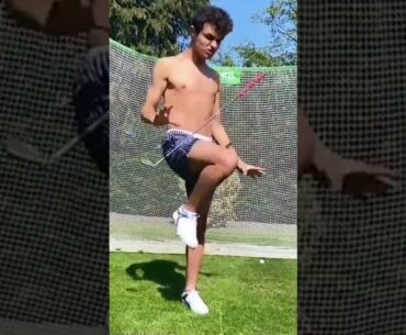 Lando Norris hits himself in the face with a golf club
