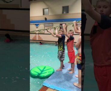 Kid goes across pool in clothes