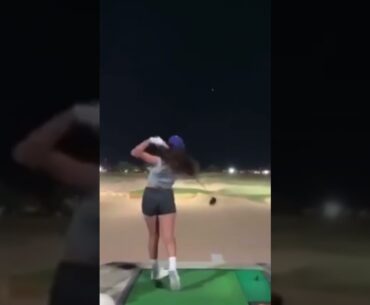 Girl practicing golf at driving range