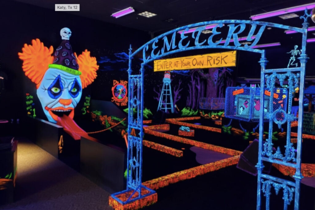 Image shows a glow-in-the-dark mini-golf course at Monster Mini-Golf in Houston.