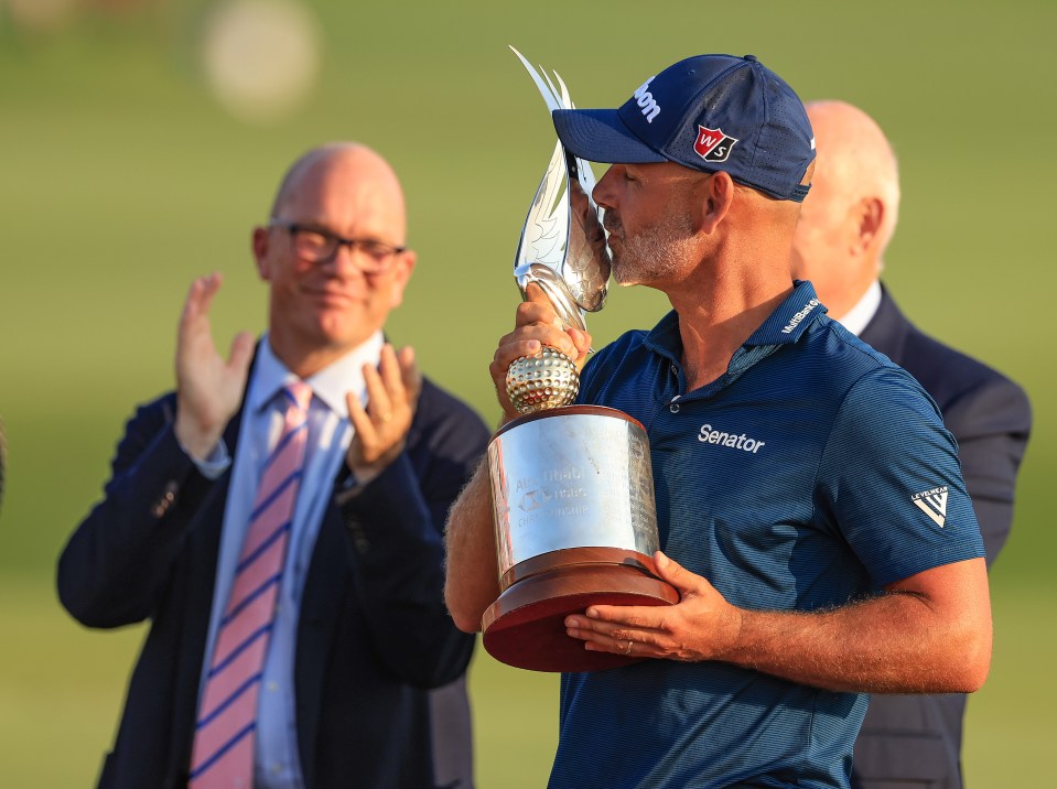 Paul Waring of England holds the trophy after his win in the final round of the Abu Dhabi HSBC Championship