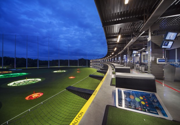 A long platform overlooking a fairway with a tall fence.