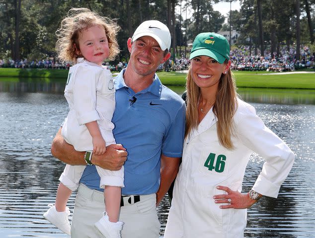 Andrew Redington/Getty Rory McIlroy and Erica Stoll with their daughter, Poppy, at the Par 3 contest prior to the 2023 Masters Tournament
