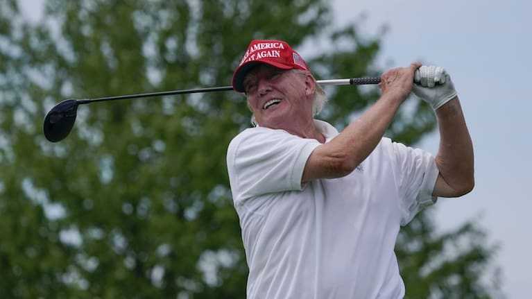 Former US President Donald Trump plays golf in 2022.