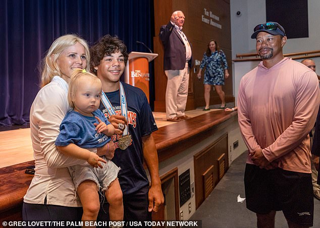 Woods pictured in 2024 standing to one side as Nordegren and Charlie pose for a photo