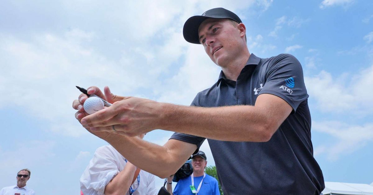 Jordan Spieth autographs a golf ball
