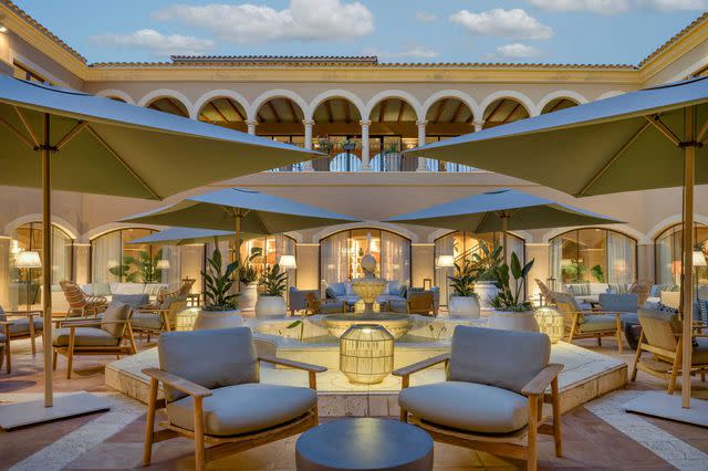 Miguel Merino/Courtesy of Hacienda Son Antem Golf Resort, Autograph Collection Comfy lounge chairs in the courtyard patio