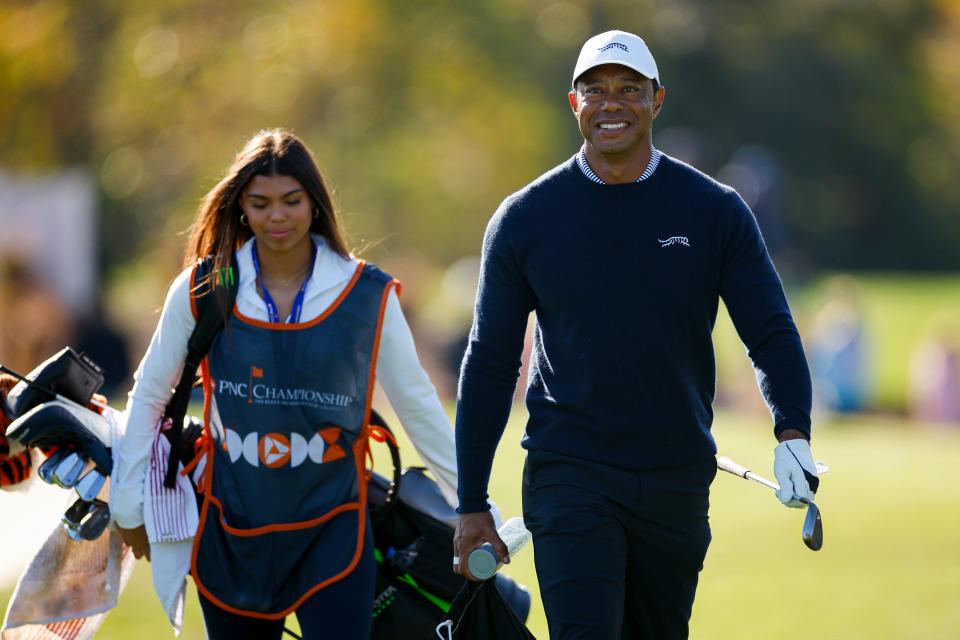 Tiger Woods and his daughter Sam Woods walk to the driving range before the first round of the PNC Championship at Ritz-Carlton Golf Club on December 21, 2024 in Orlando, Florida.