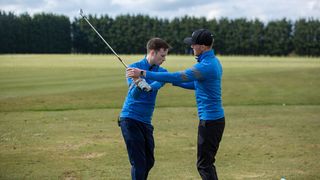 A PGA professional giving a lesson to an amateur golfer