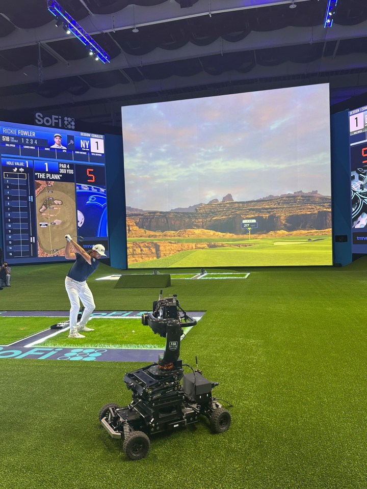 Rickie Fowler hits into the massive simulator screen at the SoFi Center in Palm Beach Gardens