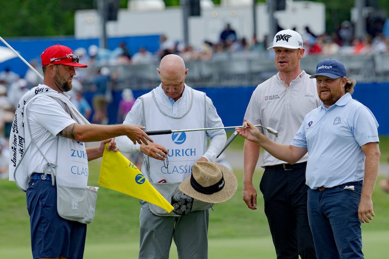 Zac Blair, right, and Patrick Fishburn, second from right, finish off their round on the 18th hole during the third round of the PGA Zurich Classic golf tournament at TPC Louisiana in Avondale, La., Saturday, April 27, 2024. (AP Photo/Matthew Hinton)