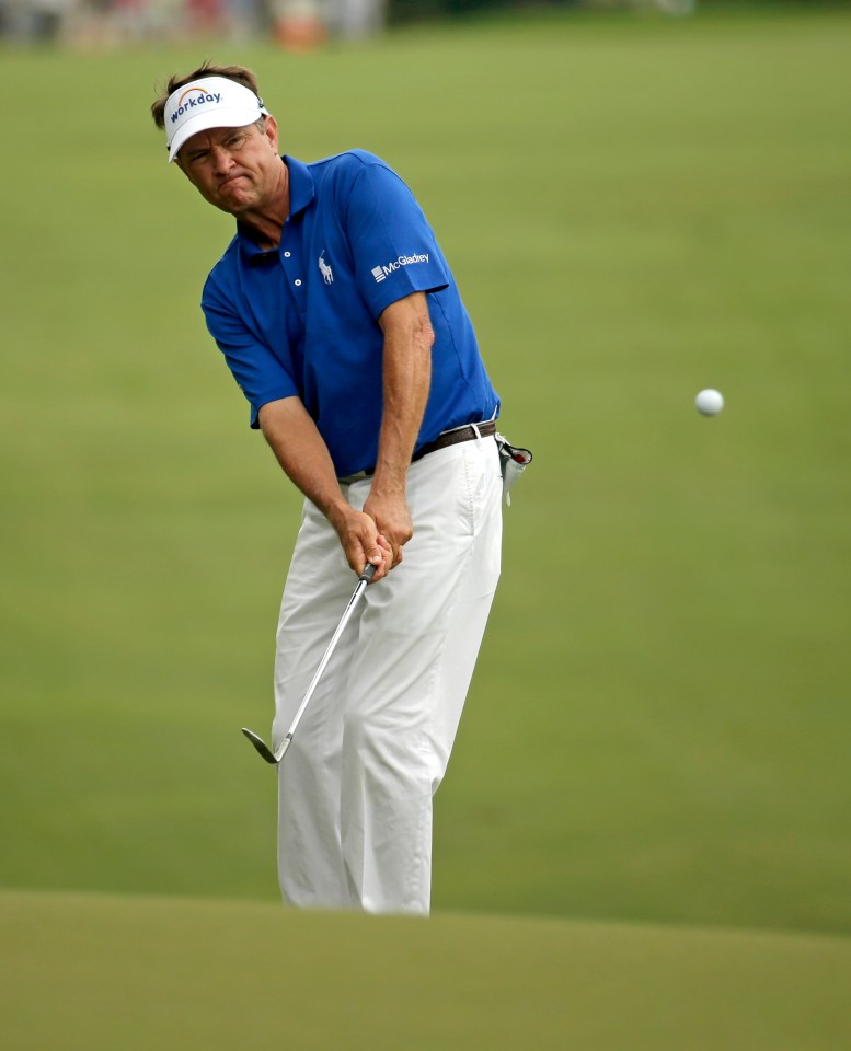 Davis Love III chipping on a golf course.