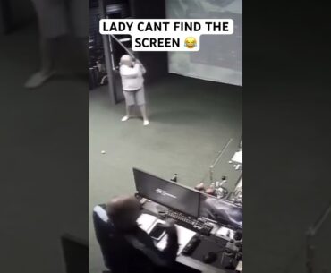 Lady aims away from the golf simulator screen and hits the wall