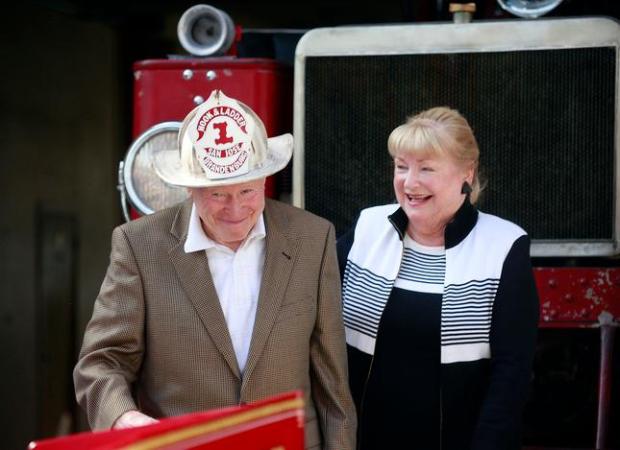 Lee Brandenburg dons a fire helmet given to him by...