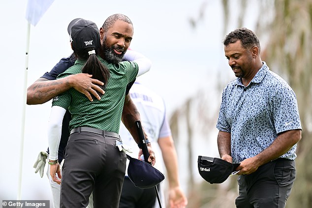 NFL icon Charles Woodson and actor Alfonso Ribeiro hug LPGA pro Celine Boutier on the 18th