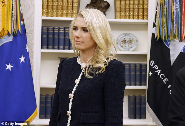 Natalie Harp stands in the Oval Office while President Donald Trump signs executive orders on January 23