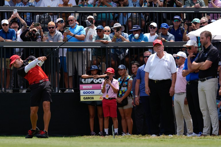 Republican presidential candidate former President Donald Trump, fourth from right, stands with his son Eric Trump, right, as they watch golfer Sergio Garcia tee off on the first hole in the final round of LIV Golf Miami, at Trump National Doral Golf Club, Sunday, April 7, 2024, in Doral, Fla. (AP Photo/Rebecca Blackwell)