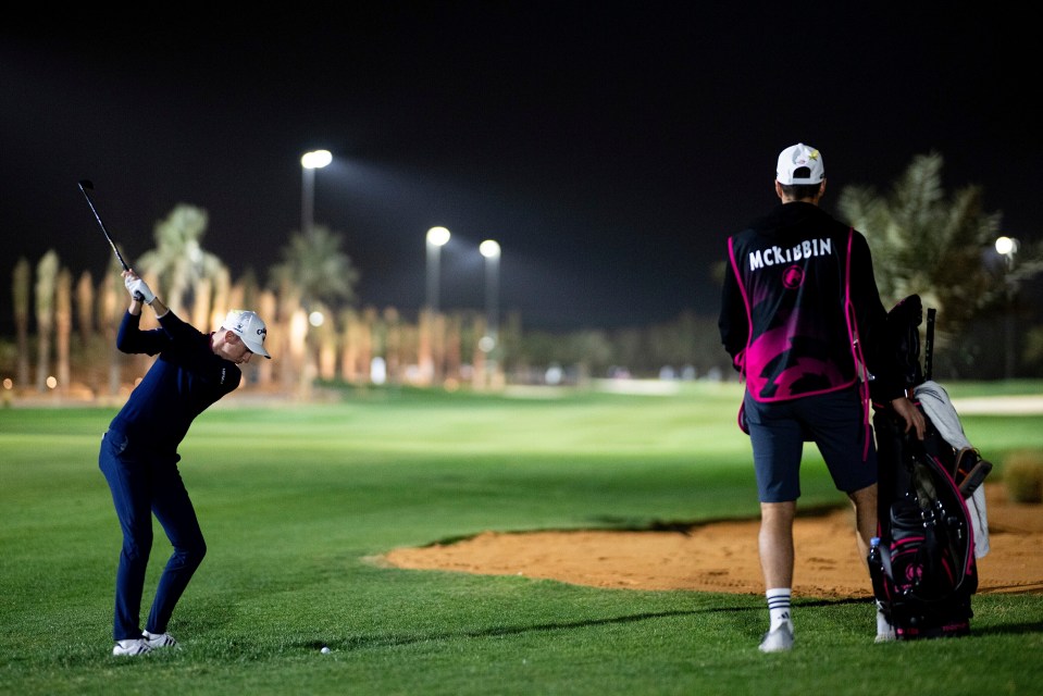 Tom McKibbin, left, of Legion XIII, hits from the fairway on the 11th hole during the second round of LIV Golf Riyadh at Riyadh Golf Club, Friday, Feb. 7, 2025, in Riyadh, Saudi Arabia. (Matthew Harris/LIV Golf via AP)