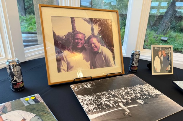 A framed photograph of Arnold Palmer and Lee Brandenburg is...