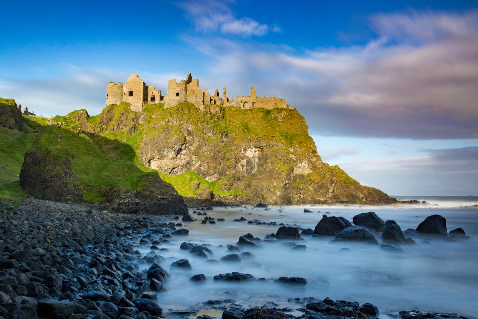 Dunluce Castle ruins on a rocky coast.