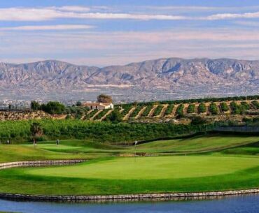 a golf course with mountains in the background