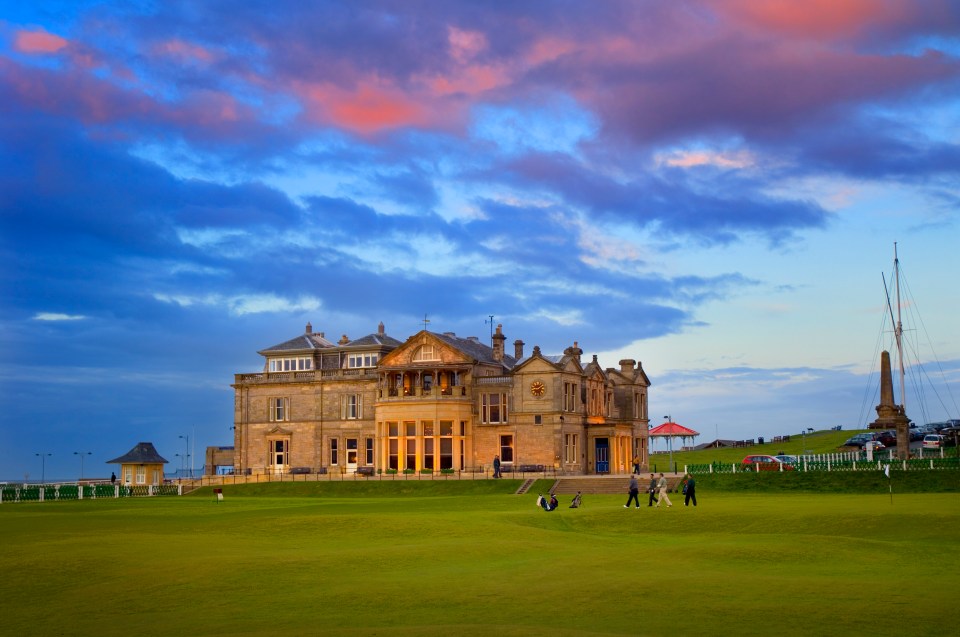 Golfers on the Old Course at St Andrews, Scotland, with the clubhouse in the background.