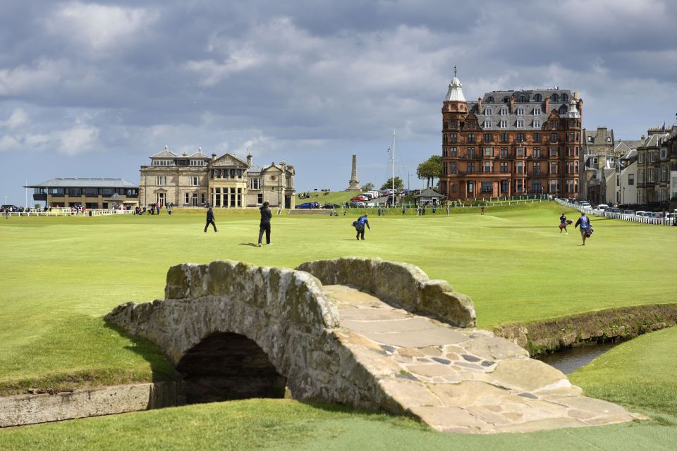 Golfers on the 18th hole of the Old Course at St Andrews, with the Royal and Ancient Golf Club clubhouse in the background.