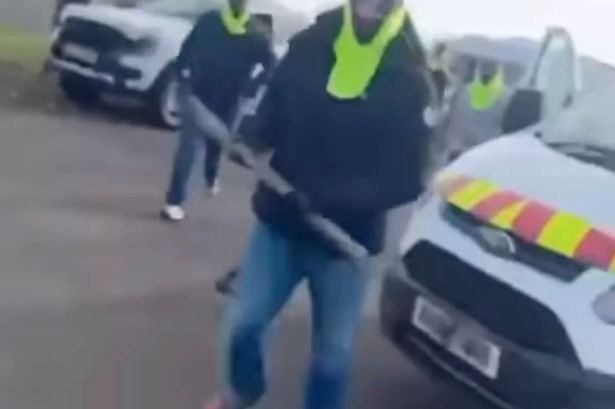 A masked man carrying a pole
