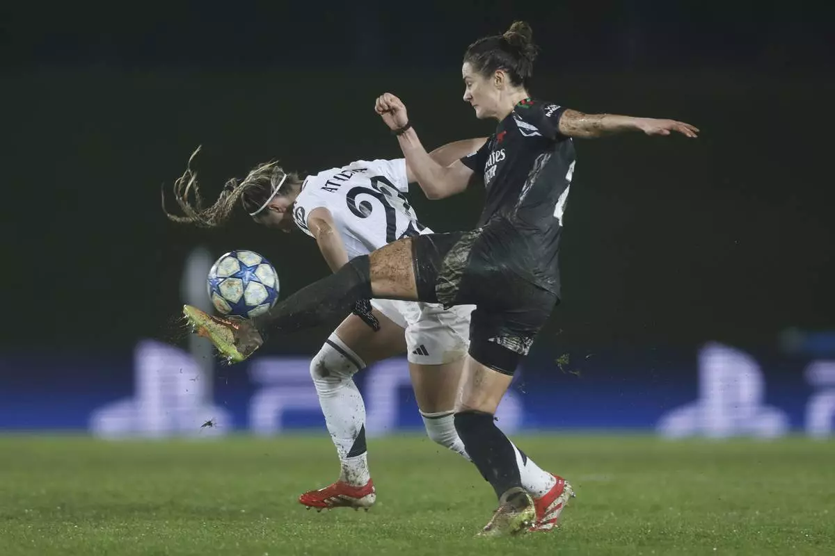 Real Madrid's Athenea del Castillo, left, challenges for the ball with Arsenal's Emily Fox during the Women's Champions League quarterfinal first leg soccer match between Real Madrid and Arsenal at the Alfredo di Stefano stadium in Madrid, Spain, Tuesday March 18, 2025. (AP Photo/Fran Berg)