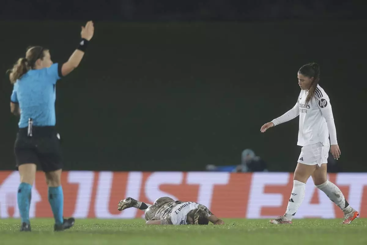Real Madrid's Melanie Leupolz lies on the ground after getting hurt during the Women's Champions League quarterfinal first leg soccer match between Real Madrid and Arsenal at the Alfredo di Stefano stadium in Madrid, Spain, Tuesday March 18, 2025. (AP Photo/Fran Berg)