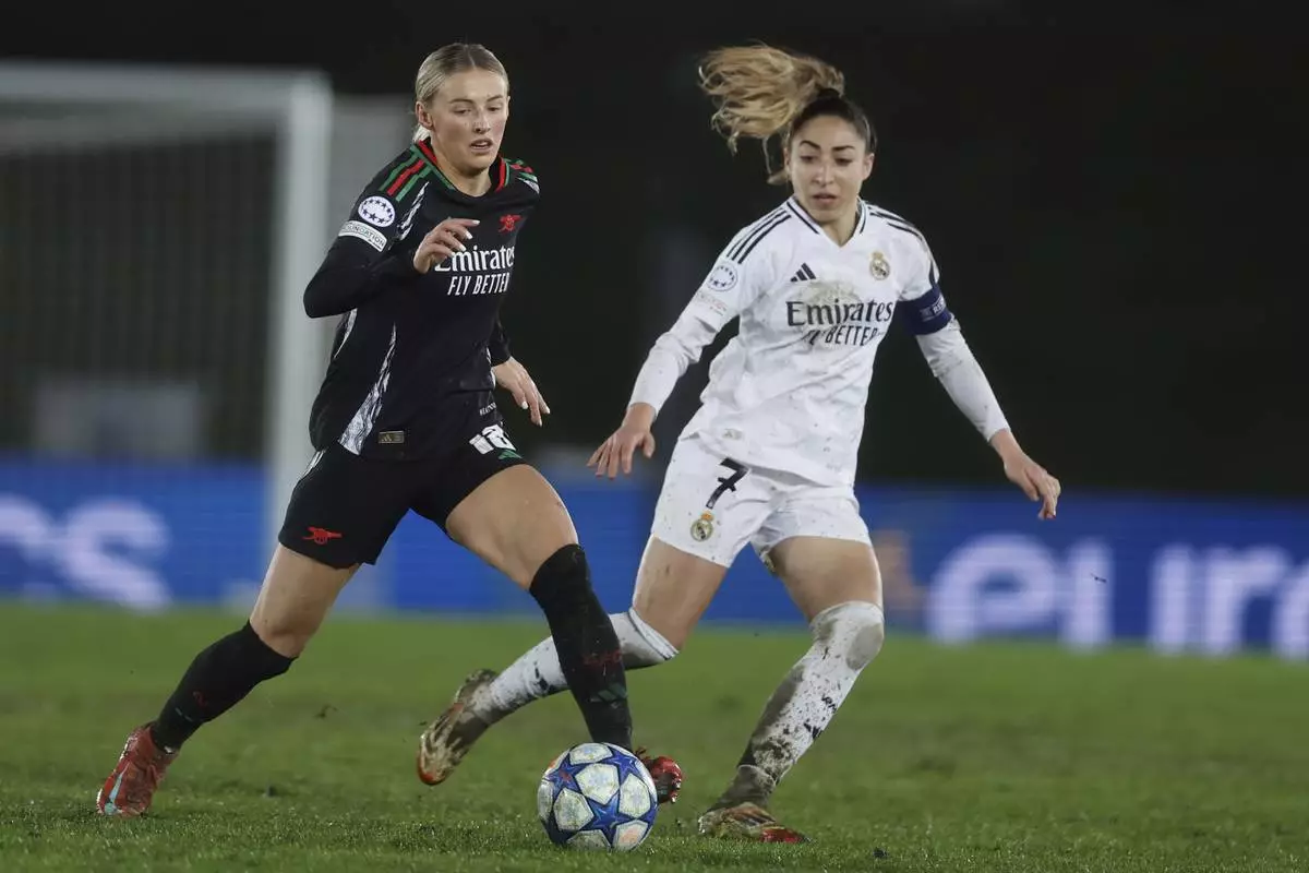 Arsenal's Chloe Kelly, left is chased by Real Madrid's Olga Carmona during the Women's Champions League quarterfinal first leg soccer match between Real Madrid and Arsenal at the Alfredo di Stefano stadium in Madrid, Spain, Tuesday March 18, 2025. (AP Photo/Fran Berg)