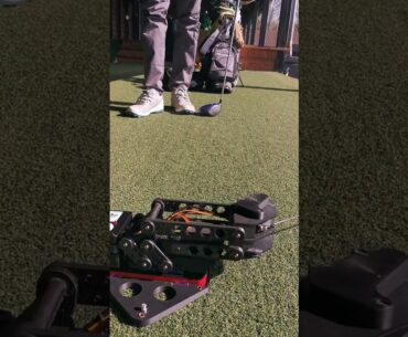 Height-adjustable electronic golf tee prototype for precise indoor fitting.