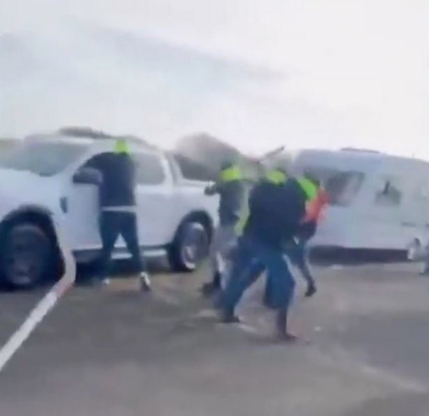 A group of men attack a white van