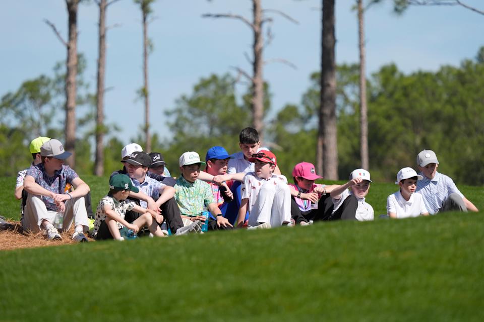 Mar 19, 2025; Graniteville, South Carolina, USA; Young patrons sit to watch Kai Trump tee off No. four during the first round of the Junior Invitational at Sage Valley Golf Club. Trump is the granddaughter of President Donald Trump. She finished at +17. Mandatory Credit: Katie Goodale - Augusta Chronicle/USA TODAY NETWORK