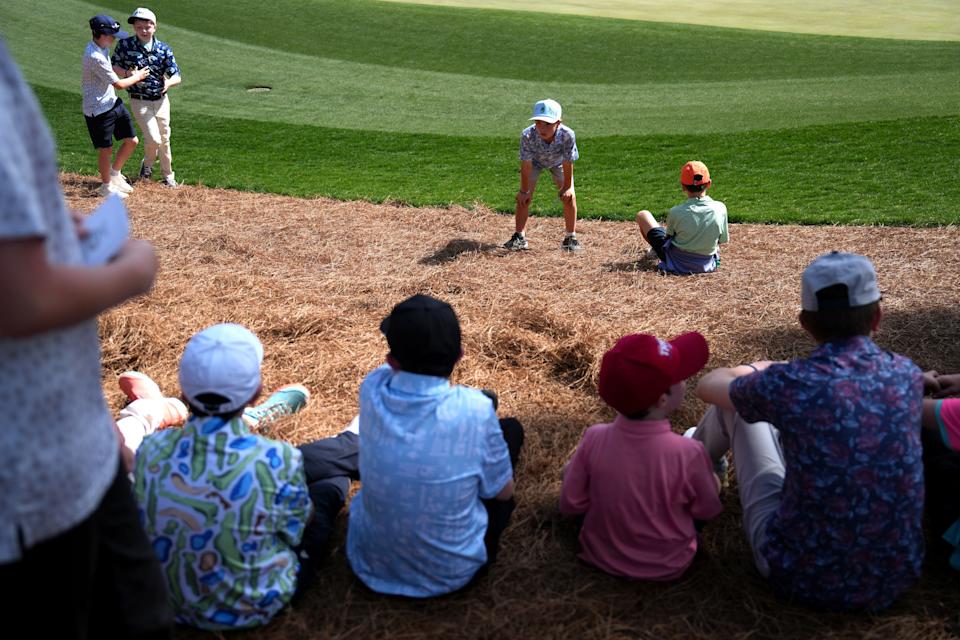 Mar 19, 2025; Graniteville, South Carolina, USA; Young patrons sit on the pine straw as they wait for Kai Trump on No. 18 green during the first round of the Junior Invitational at Sage Valley Golf Club. Trump is the granddaughter of President Donald Trump. She finished at +17. Mandatory Credit: Katie Goodale - Augusta Chronicle/USA TODAY NETWORK