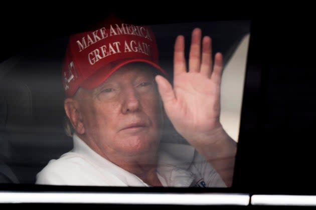 President Donald Trump waves to supporters from his limousine as he arrives at Trump International Golf Club in West Palm Beach, Florida.