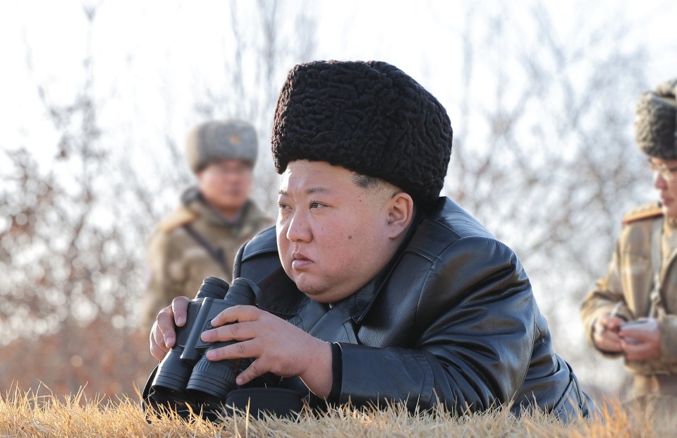 Kim Jong Un observing a strategic cruise missile launching drill through binoculars.