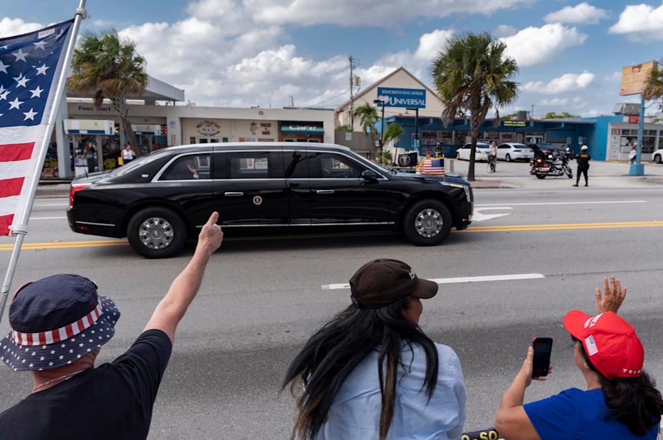 President Donald Trump waves to the crowd as his motorcade heads to Mar-a- Lago after landing on Air Force One at Palm Beach International Airport in West Palm Beach, Florida on March 28, 2025.