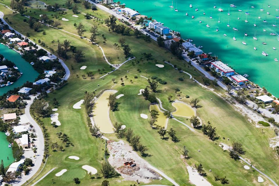 An aerial view of a golf course in the Florida Keys. The course is close to the water.