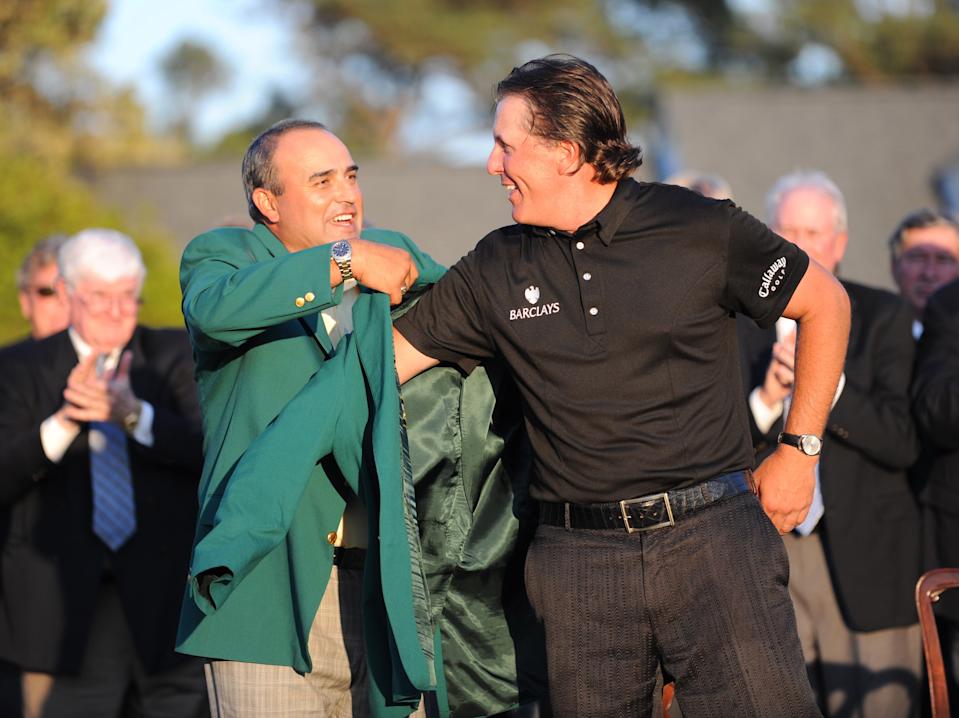 Phil Mickelson receives his Green Jacket from 2009 champion Angel Cabrera of Argentina after winning the 2010 Masters Golf Tournament at Augusta National Golf Club on April 11, 2010.