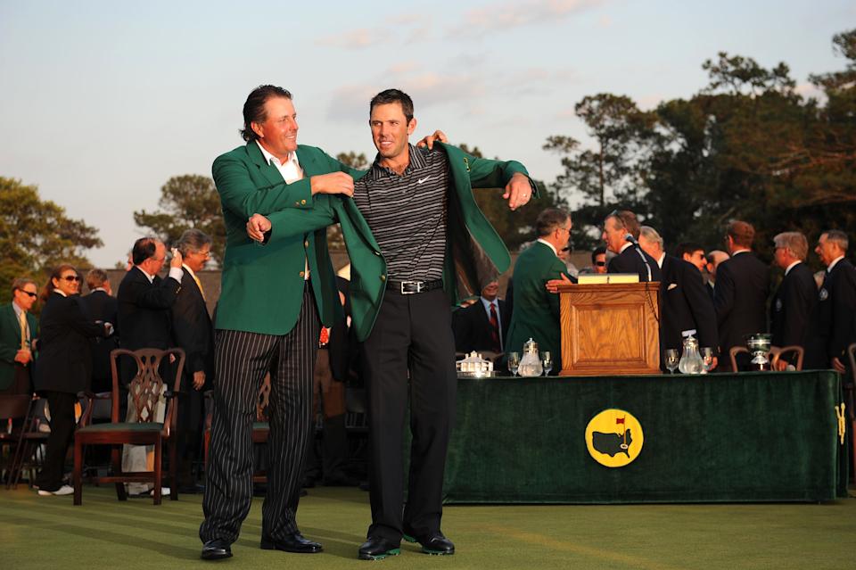 Phil Mickelson slips the green jacket on Charl Schwartzel after he won the 2011 Masters Tournament at Augusta National Golf Club. Photo by ROBYN BECK/AFP/Getty Images