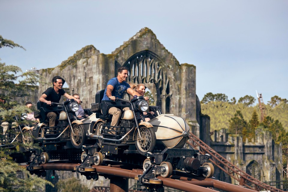 People riding a motorcycle-themed roller coaster.